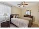 Comfortable bedroom featuring a ceiling fan, a large window with sheer curtains, and neutral walls at 580 S Clinton St # 12C, Denver, CO 80247
