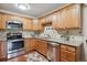 Well-lit kitchen with stainless steel appliances, granite countertops, and wood cabinetry at 580 S Clinton St # 12C, Denver, CO 80247