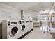 Clean laundry room with multiple washers, dryers, and folding counter at 580 S Clinton St # 12C, Denver, CO 80247