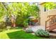 Landscaped backyard with a patio dining set, well-maintained lawn, and lush foliage at 10565 Kalahari Ct, Lone Tree, CO 80124