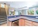 Basement kitchenette with stairs, a wine fridge, and a view of the open living area and backyard at 10565 Kalahari Ct, Lone Tree, CO 80124