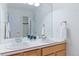 Well-lit bathroom with a dual sink vanity with chrome fixtures and a mirrored wall plus a glass-enclosed shower at 10565 Kalahari Ct, Lone Tree, CO 80124