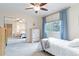 Bright bedroom with a ceiling fan, mirrored closet doors, and a large window dressed with charming blue curtains at 10565 Kalahari Ct, Lone Tree, CO 80124
