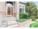 Inviting front entrance with brick accents, a well-maintained garden bed, and a decorative front door at 10565 Kalahari Ct, Lone Tree, CO 80124