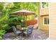 Enjoy outdoor living on this flagstone patio with a dining set and shade umbrella, surrounded by mature trees and landscaping at 10565 Kalahari Ct, Lone Tree, CO 80124