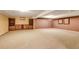 Spacious basement area with carpet, built-in shelving, and painted in neutral colors at 2840 S Heather Gardens Way # A, Aurora, CO 80014