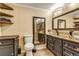 Elegant bathroom with custom cabinets, granite counters, decorative mirrors, and vessel sinks at 2840 S Heather Gardens Way # A, Aurora, CO 80014