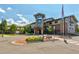 Well-maintained building exterior with a flag, manicured landscaping, and visible signage at 2840 S Heather Gardens Way # A, Aurora, CO 80014