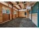 Spacious barn with concrete floor, horse stalls, and wood paneling at 4880 Tall Horse Trl, Sedalia, CO 80135