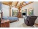 Bedroom featuring high vaulted ceilings, exposed beams, and a cozy sitting area at 4880 Tall Horse Trl, Sedalia, CO 80135
