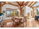Bright dining room with hardwood floors, wooden beams, a large window, and a wooden dining table at 4880 Tall Horse Trl, Sedalia, CO 80135