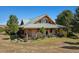Exterior of home with a green metal roof and wooden support beams with covered porch at 4880 Tall Horse Trl, Sedalia, CO 80135