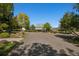View of a country home with green roof and mature trees under clear blue sky on a sunny day at 4880 Tall Horse Trl, Sedalia, CO 80135
