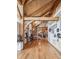 Grand foyer features hardwood floors, an intricate staircase, and beautiful wood beam architecture at 4880 Tall Horse Trl, Sedalia, CO 80135