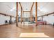 Open concept living room featuring wooden support beams and warm wood flooring at 4880 Tall Horse Trl, Sedalia, CO 80135