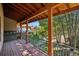 Covered porch with wooden beams overlooking a lush yard with mature landscaping at 4880 Tall Horse Trl, Sedalia, CO 80135