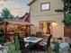 Cozy backyard with string lights, a dining table, bar area and lush foliage, creating a private retreat at 109 Bear Creek Ln, Morrison, CO 80465