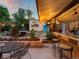 Outdoor patio with bar area with lights, dining area, and landscaping at 109 Bear Creek Ln, Morrison, CO 80465
