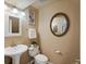 Bathroom featuring a pedestal sink, toilet, and a round mirror, all in a neutral color scheme at 109 Bear Creek Ln, Morrison, CO 80465