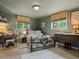 Cozy bedroom with wrought iron bed frame, carpeted floors, and serene views from the windows at 109 Bear Creek Ln, Morrison, CO 80465