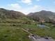 Expansive mountain landscape with rolling hills, lush meadows, scenic walking trails, and serene lake views at 109 Bear Creek Ln, Morrison, CO 80465