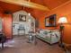 Inviting living room with wood floors, exposed beams, and an orange accent wall at 109 Bear Creek Ln, Morrison, CO 80465