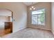 Bright dining room area with large window, chandelier, and hardwood floors that flow into the kitchen at 2792 S Ceylon St, Aurora, CO 80013