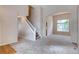 Bright entryway featuring carpeted floors, staircase, and open access to the dining and living area at 2792 S Ceylon St, Aurora, CO 80013