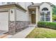 View of the home's front entrance featuring stone accents, manicured landscaping, and a covered porch at 2792 S Ceylon St, Aurora, CO 80013