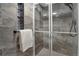 Bathroom shower with glass door, gray marble tile, and a shower head with handheld sprayer at 4800 E Hale Pkwy # 712N, Denver, CO 80220