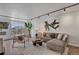 Comfortable living room boasts hardwood floors, large windows with a city view, and stylish, neutral-toned furniture at 4800 E Hale Pkwy # 712N, Denver, CO 80220