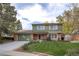 Charming two-story home with brick and green siding, manicured lawn, and mature trees at 12945 Columbine Cir, Thornton, CO 80241