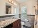 Updated bathroom featuring granite countertop, modern vanity, neutral tiled walls, and updated lighting at 2775 California St, Denver, CO 80205