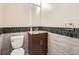 Cozy half bathroom with wood cabinets, granite countertop, modern mirror, and tiled backsplash at 2775 California St, Denver, CO 80205
