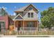 Charming two-story home with a brick facade, covered porch, and fenced yard at 2775 California St, Denver, CO 80205
