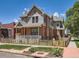 Attractive home featuring a front porch, brick accents, and well-maintained lawn at 2775 California St, Denver, CO 80205