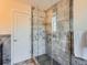 Modern glass enclosed shower with tiled walls, updated fixtures, and contrasting tile flooring at 2775 California St, Denver, CO 80205
