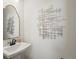 Elegant half-bathroom featuring a pedestal sink, decorative mirror, and unique wall decor at 1039 Highview Dr, Erie, CO 80516