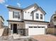 Charming two-story home featuring a white exterior, brick accents, and an attached two-car garage at 1039 Highview Dr, Erie, CO 80516