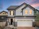 Charming two-story home at dusk featuring a white exterior, brick accents, and an attached two-car garage at 1039 Highview Dr, Erie, CO 80516