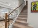 Carpeted staircase with wood and iron banister leading to the upper level at 1039 Highview Dr, Erie, CO 80516
