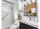 Compact bathroom with a tiled shower-tub, sleek vanity, and modern fixtures at 4455 Brentwood St, Wheat Ridge, CO 80033