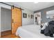 Stylish bedroom featuring a sliding barn door, hardwood floors, and neutral decor at 4455 Brentwood St, Wheat Ridge, CO 80033