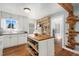 Bright kitchen with a spacious island, open shelving, and lots of natural light at 4455 Brentwood St, Wheat Ridge, CO 80033