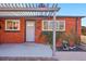 Front view of a brick home with a grey door and pergola at 3324 N Glencoe St, Denver, CO 80207