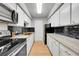 Modern galley kitchen with white cabinets, quartz countertops and gold fixtures at 1020 15Th St # 27E, Denver, CO 80202