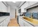 Modern kitchen with white cabinets, gold fixtures, and dark tile backsplash at 1020 15Th St # 27E, Denver, CO 80202