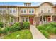Inviting townhome featuring a red front door, stone accents, and manicured landscaping at 22801 E Briarwood Pl, Aurora, CO 80016