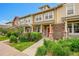 Townhome with manicured lawn, stone accents, colorful shrubbery and inviting red front door at 22801 E Briarwood Pl, Aurora, CO 80016