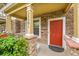 Close-up of charming front porch with stone pillars and a vibrant red front door at 22801 E Briarwood Pl, Aurora, CO 80016